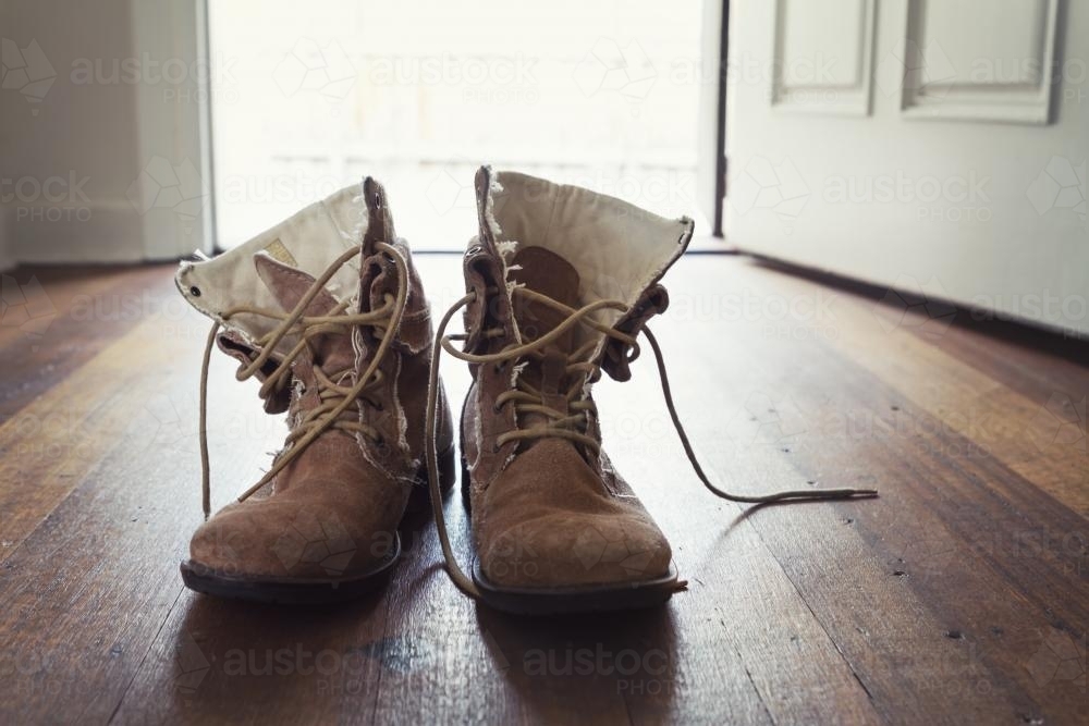 Old tradie work boots in doorway of suburban home - Australian Stock Image