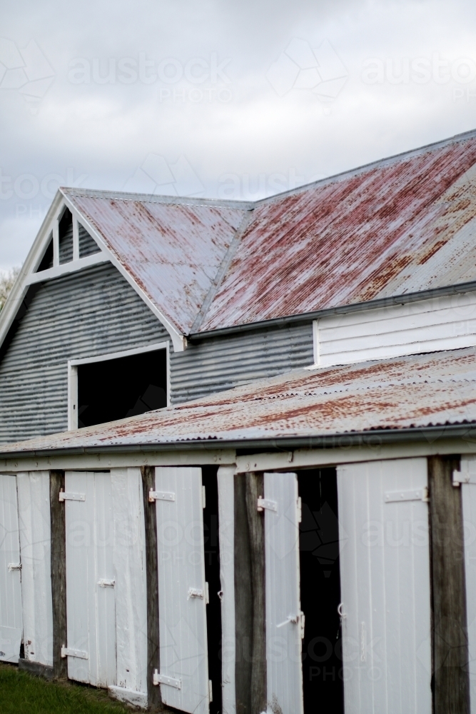 Old weathered work shed with timber doors and corrugated iron roofs - Australian Stock Image