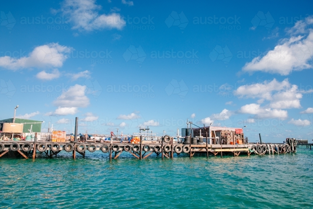 Old wooden fishing jetty with shacks and sheds - Australian Stock Image