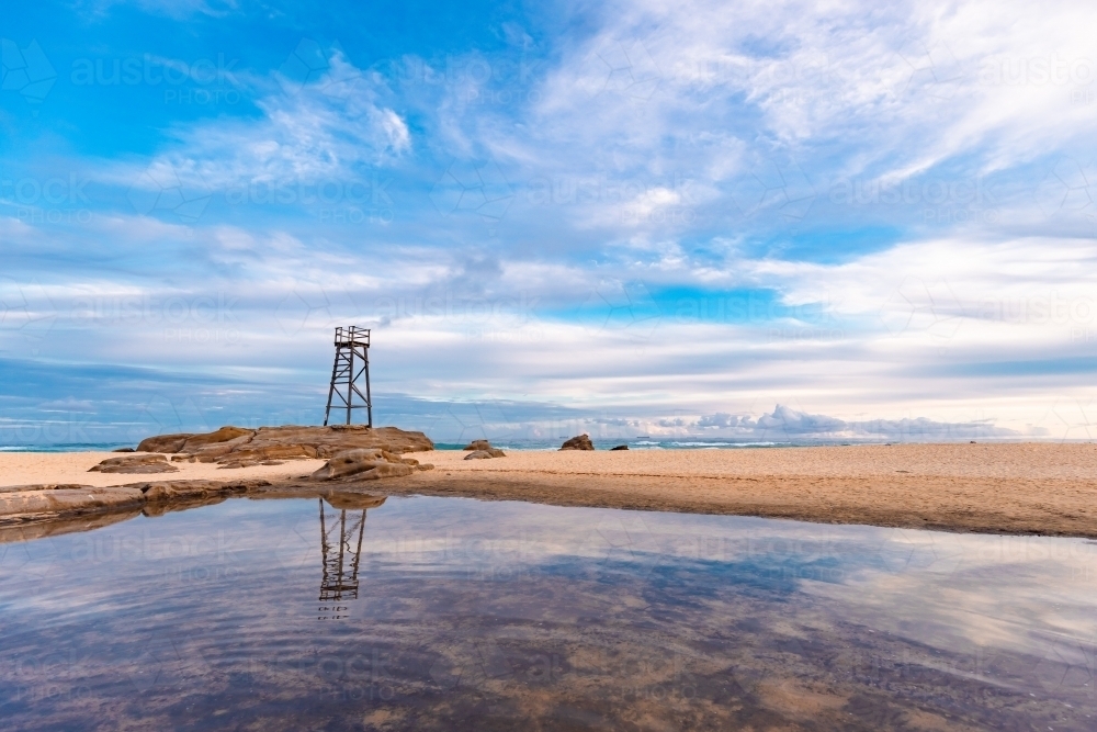 Old wooden lifeguard, shark lookout tower on Redhead Beach with reflection - Australian Stock Image
