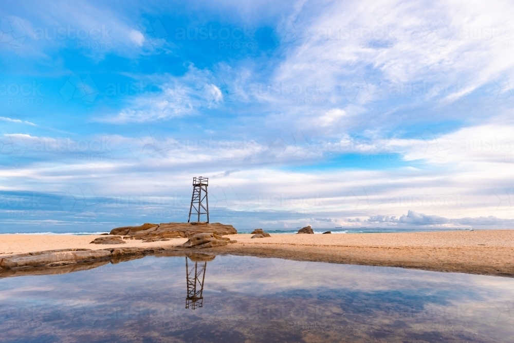 Old wooden lifeguard, shark lookout tower on Redhead Beach with reflection - Australian Stock Image
