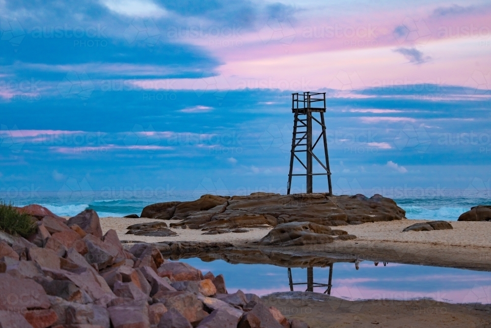Old wooden lifeguard, shark lookout tower on Redhead Beach with reflection - Australian Stock Image
