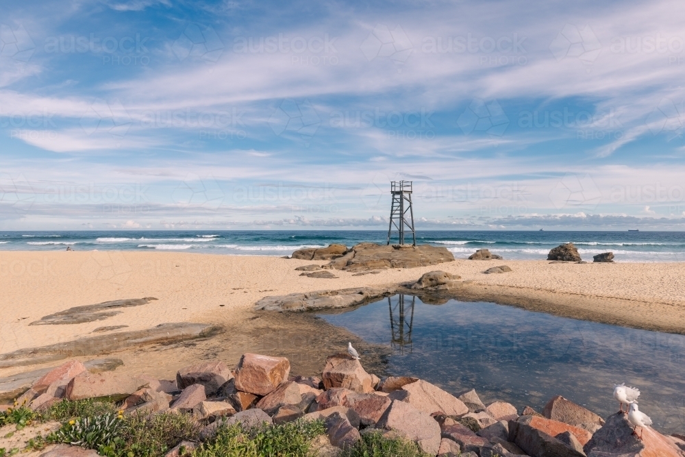 Old wooden lifeguard, shark lookout tower on Redhead Beach with reflection - Australian Stock Image