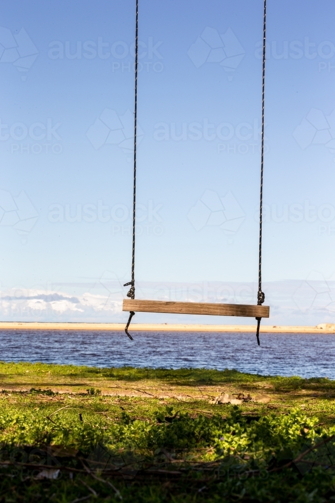 Old wooden swing with ocean horizon background - Australian Stock Image