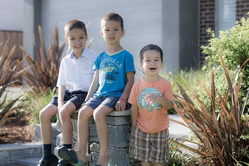 Older brother says goodbye to his siblings on his first day back at school - Australian Stock Image