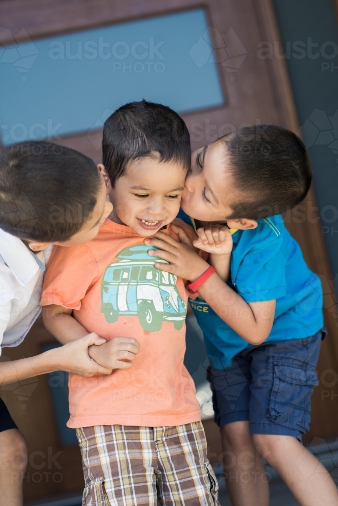 Older brother says goodbye to his siblings on his first day back at school - Australian Stock Image