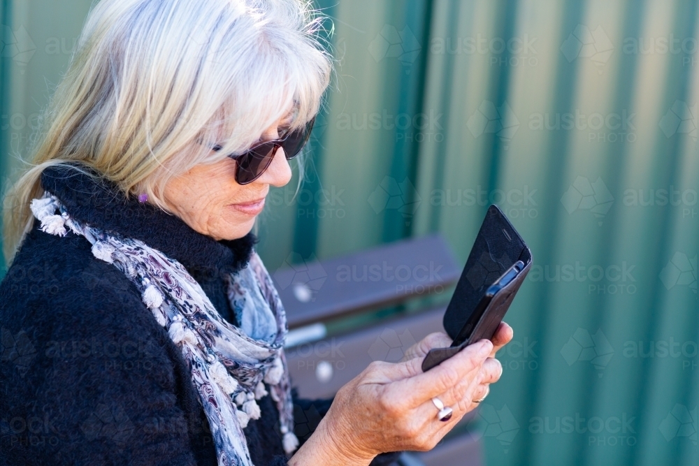 Older lady looking at smartphone - Australian Stock Image
