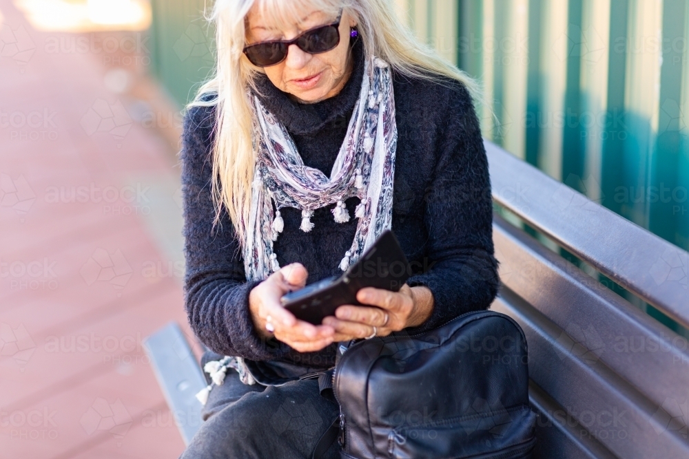 Older lady looking at smartphone - Australian Stock Image