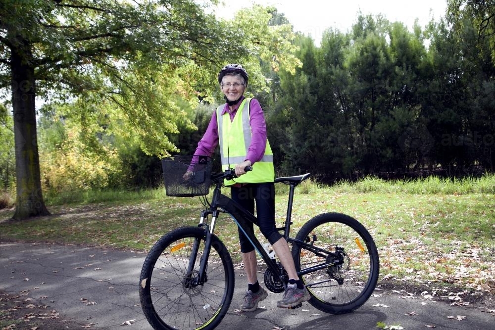 Older lady riding bike - Australian Stock Image