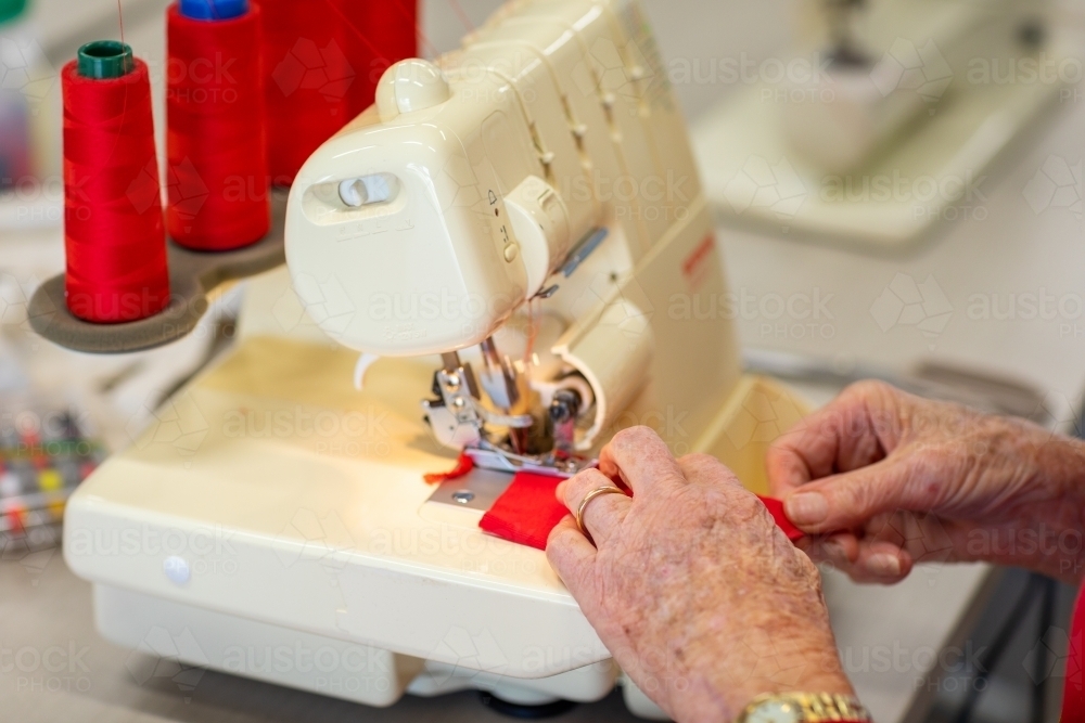 older lady's hands working at sewing machine - Australian Stock Image