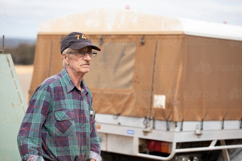 older man in checked flanno near vehicle - Australian Stock Image