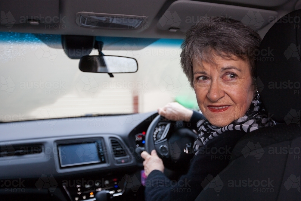 Older woman backing car out of driveway - Australian Stock Image