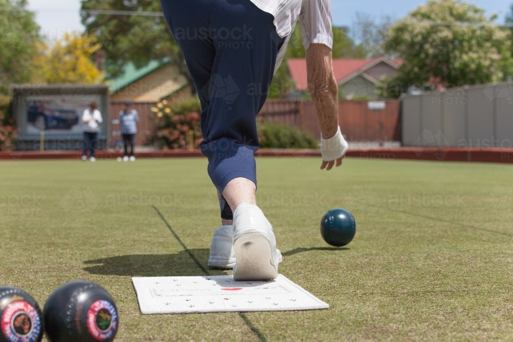 Older woman delivering a lawn bowl - Australian Stock Image