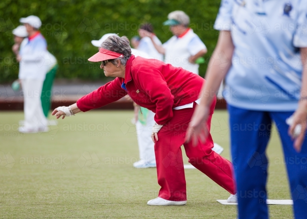 Older woman delivering a lawn bowl - Australian Stock Image