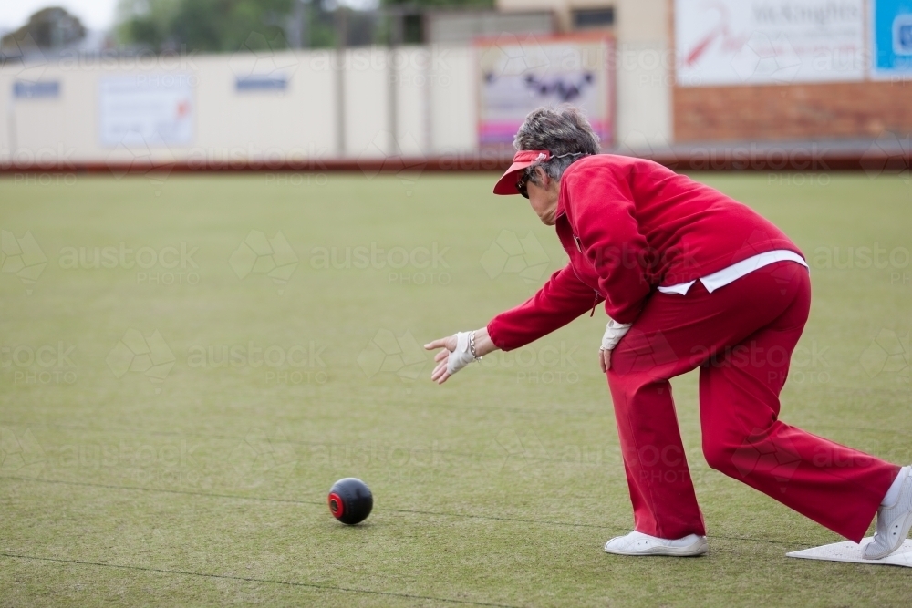 Older woman delivering a lawn bowl - Australian Stock Image