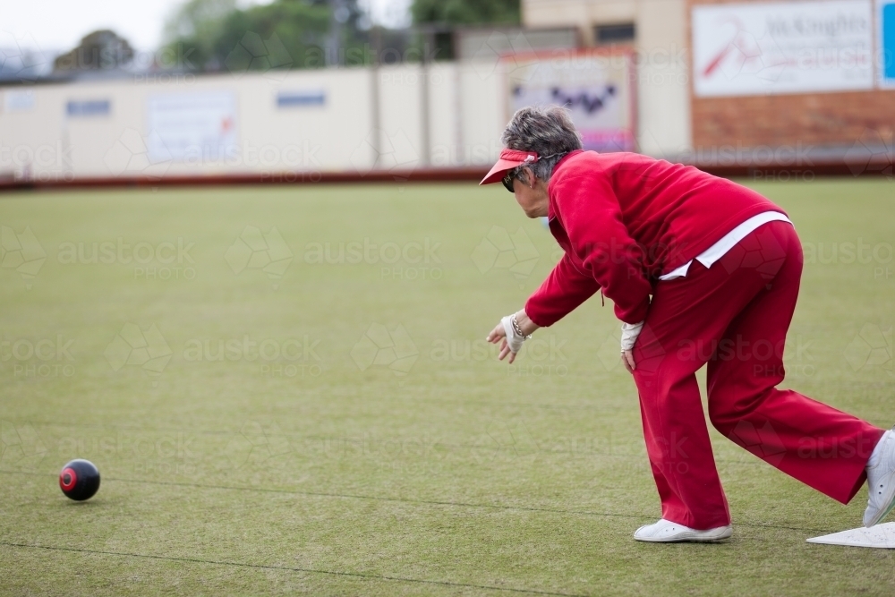 Older woman delivering a lawn bowl - Australian Stock Image