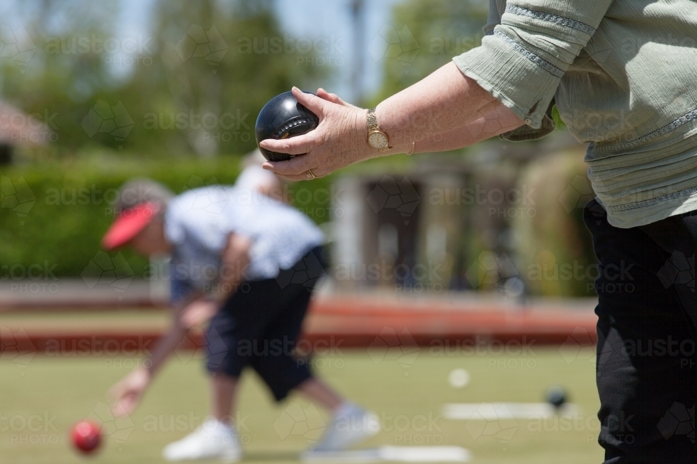 Older woman lining up her lawn bowl - Australian Stock Image