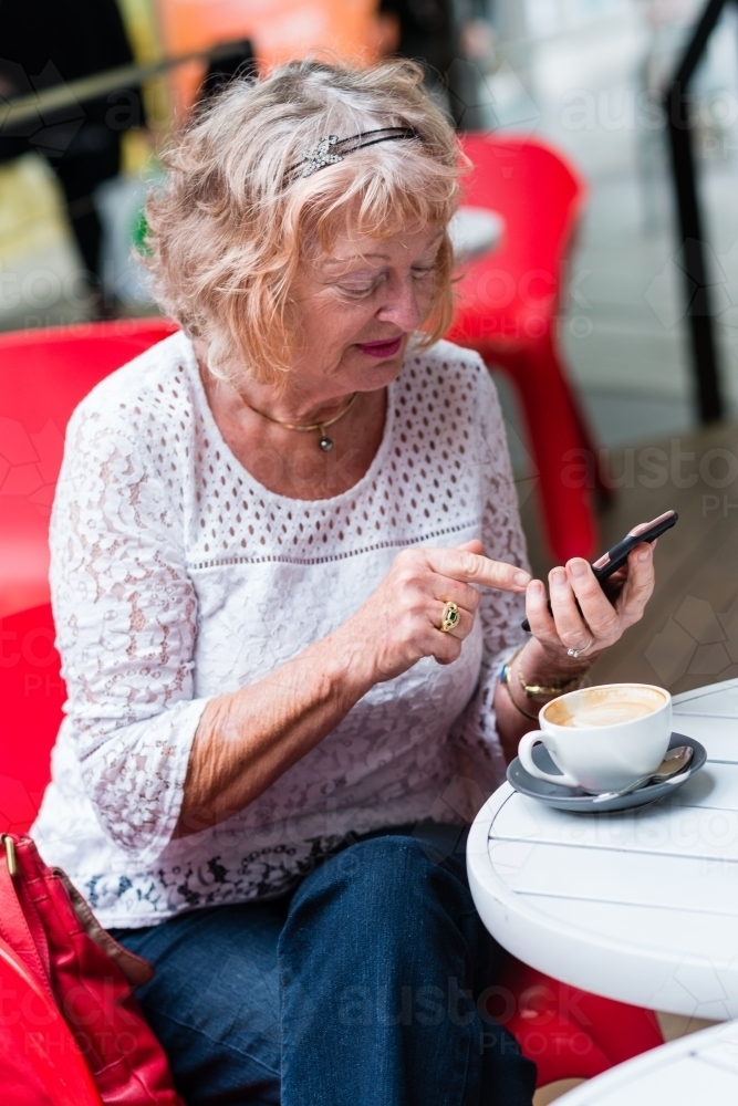 Image of older woman using mobile phone - Austockphoto