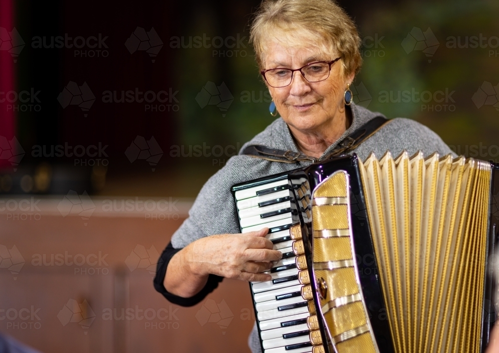 older woman woman playing piano accordion - Australian Stock Image