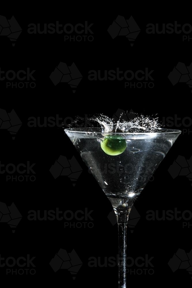 olive splashing into a martini - Australian Stock Image