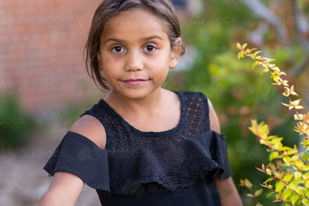one aboriginal child wearing black looking at camers - Australian Stock Image