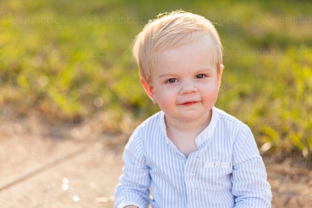 Image Of One Year Old Boy Sitting On Footpath Backlit By Evening Light image-of-one-year-old-boy-sitting-on-footpath-backlit-by-evening-light