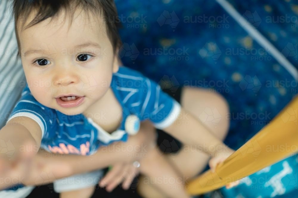 One year old mixed race boy rides with his mother on a Sydney city train - Australian Stock Image