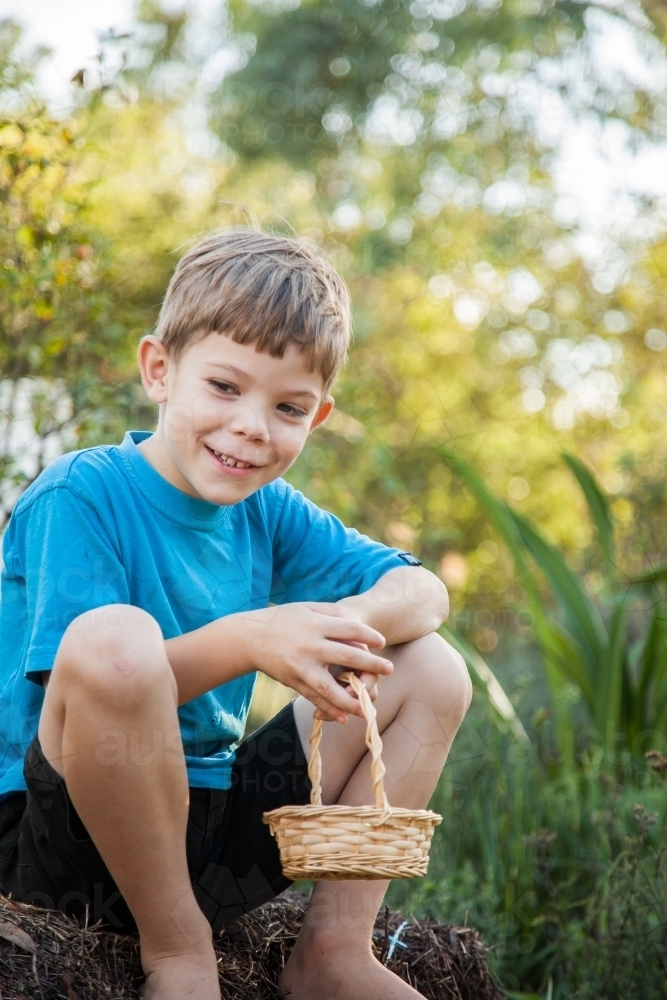 One young boy holding cane basket ready for Easter egg hunt - Australian Stock Image