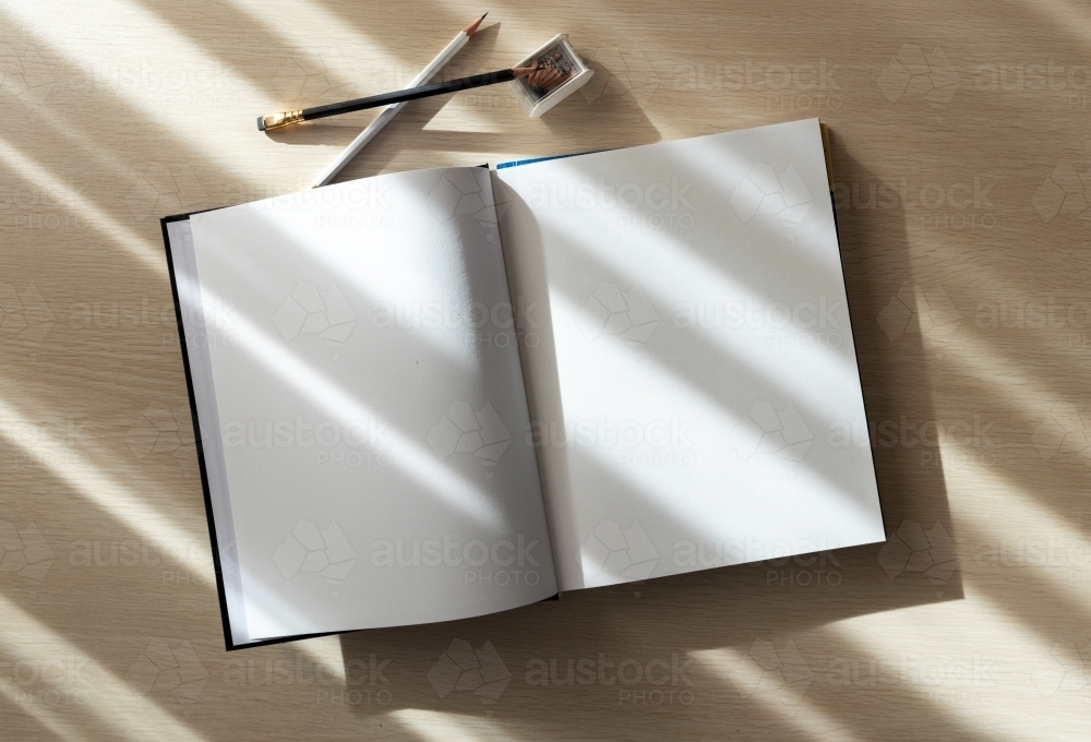 open book with blank pages and pencils - Australian Stock Image