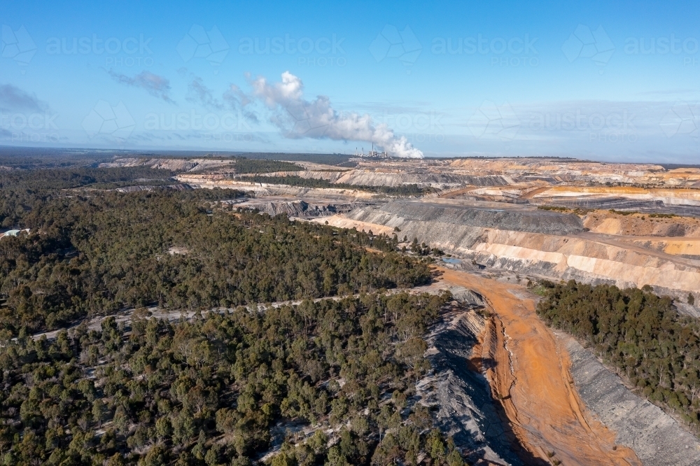 open cut coal mine with coal-fired power station in distance - Australian Stock Image