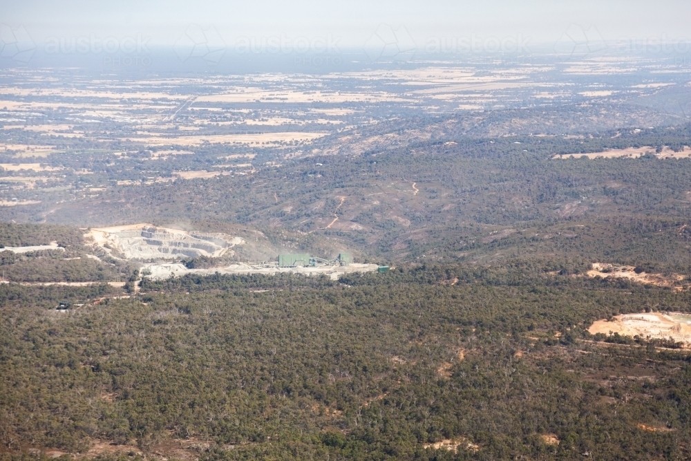 Open cut mine or quarry seen from the air among trees - Australian Stock Image