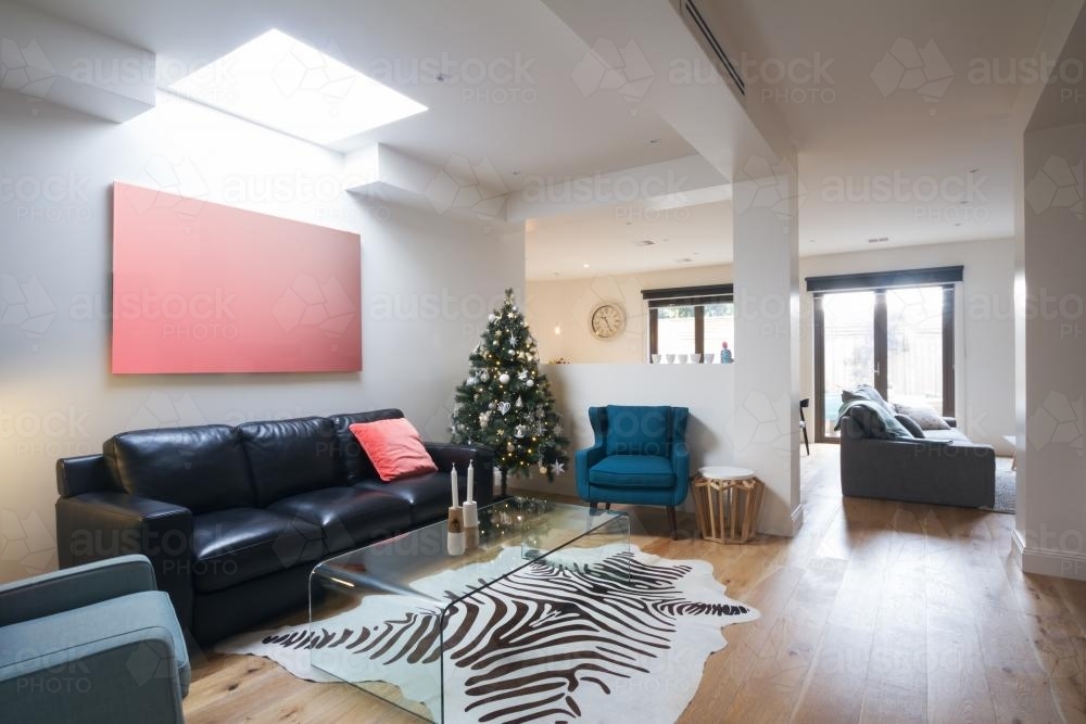 Open plan casual living room in contemporary home with christmas tree - Australian Stock Image