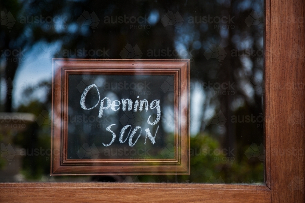 Image of Opening Soon sign on glass shop door - Austockphoto