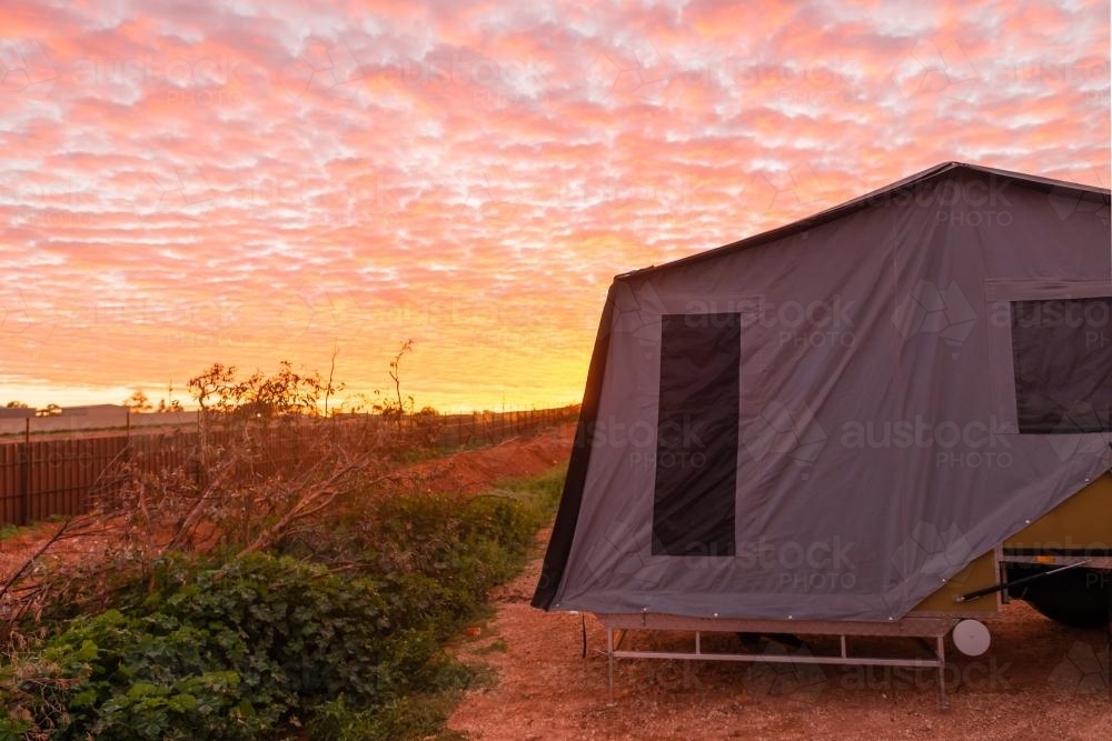 Orange and pink sunrise clouds at a caravan park in the outback - Australian Stock Image