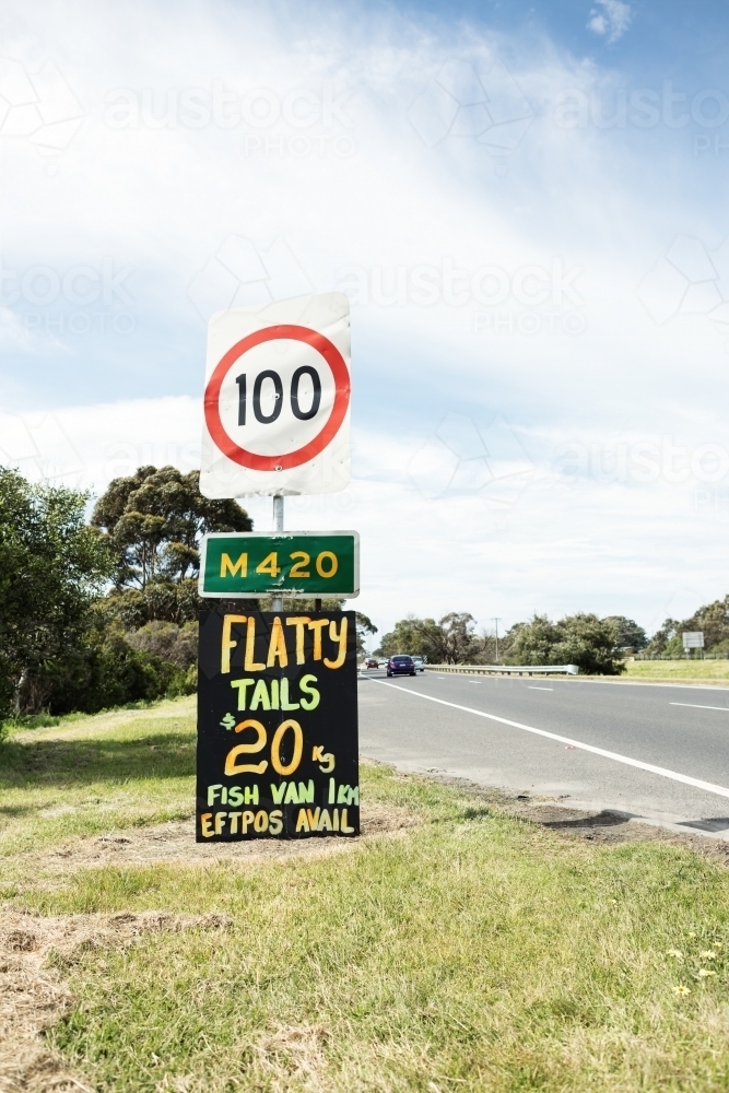 Orange and yellow roadside sign advertising flathead tails vertical - Australian Stock Image