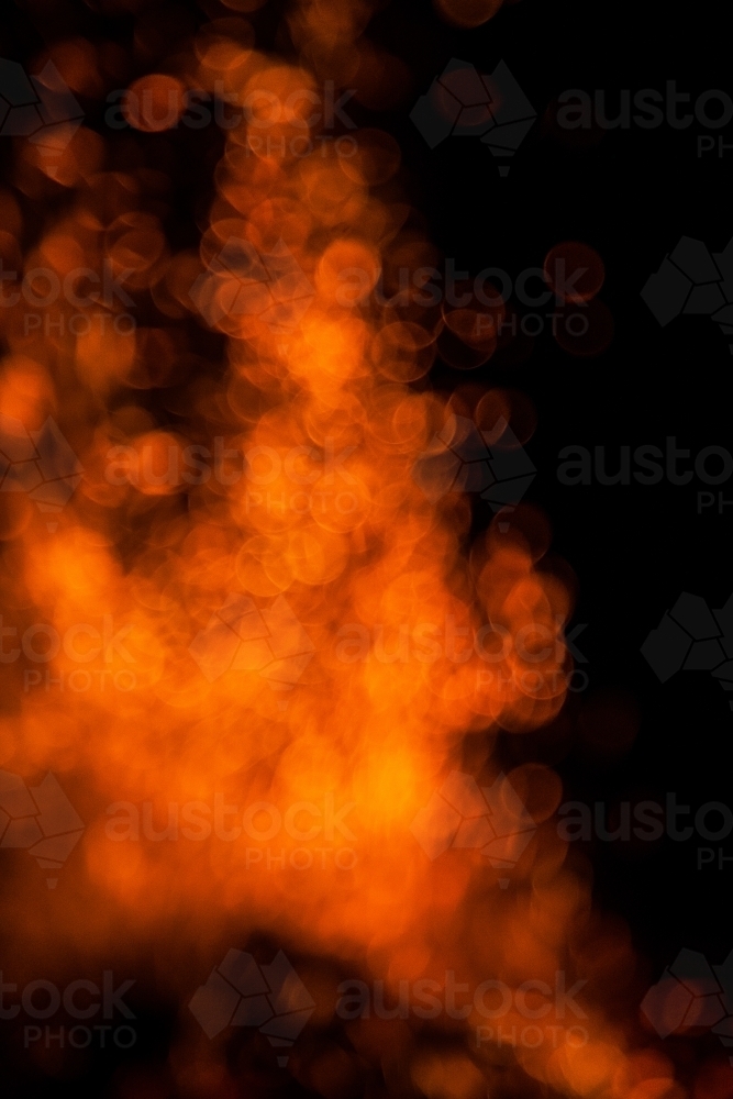 Orange bokeh of firelight in the night - Australian Stock Image