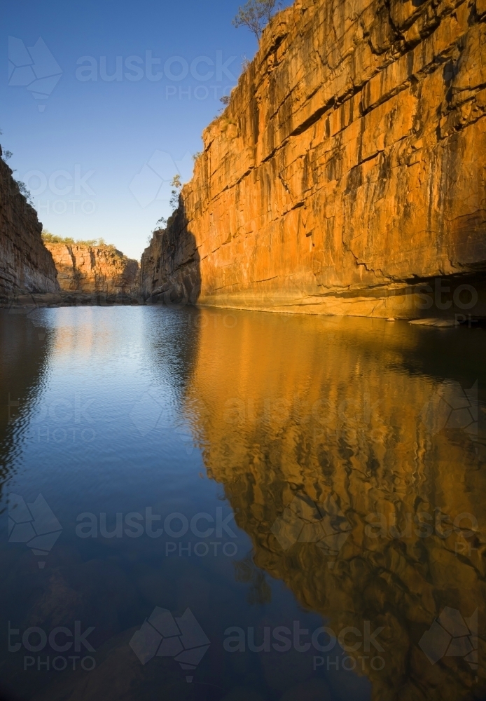 Orange cliff and blue sky reflected in pool, Katherine Gorge, Nitmiluk National Park - Australian Stock Image