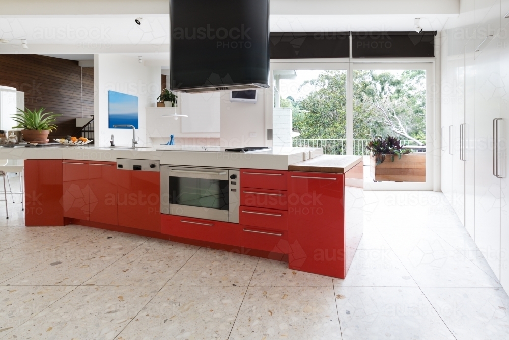Orange kitchen cabinets in island bench in modern luxury home - Australian Stock Image