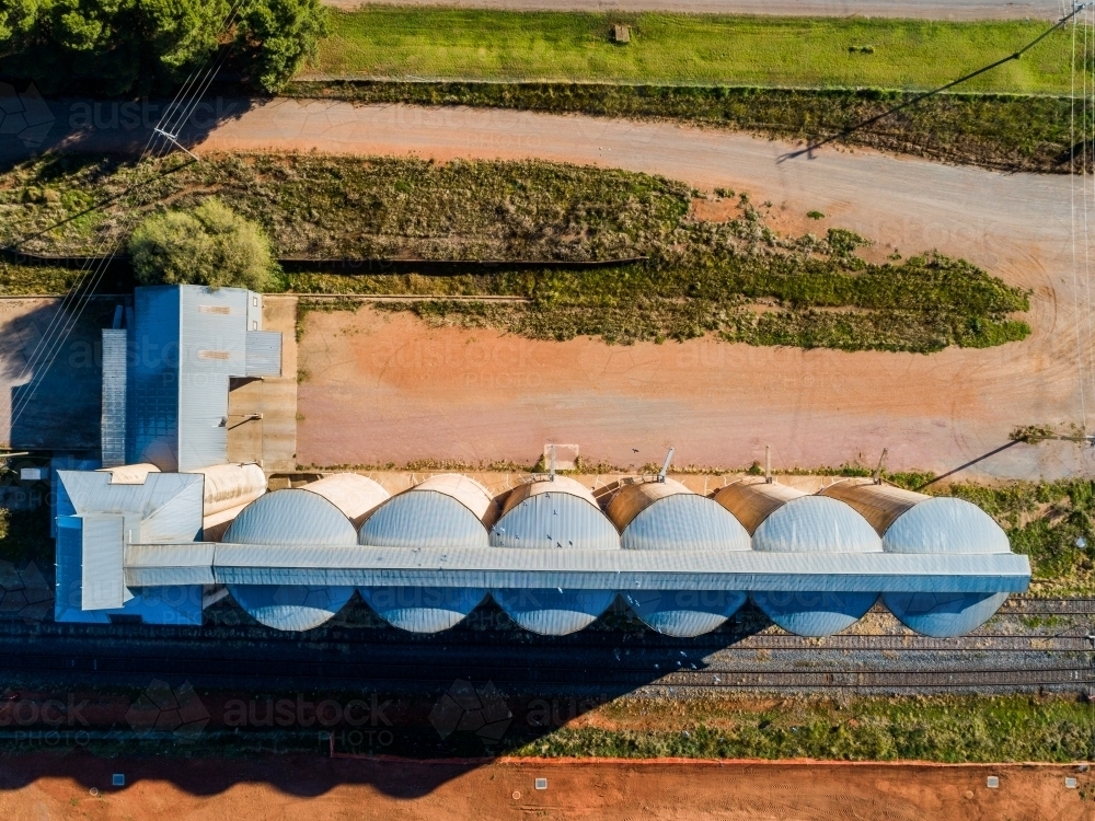 Orange red dirt beside silos in rural Australia - Australian Stock Image
