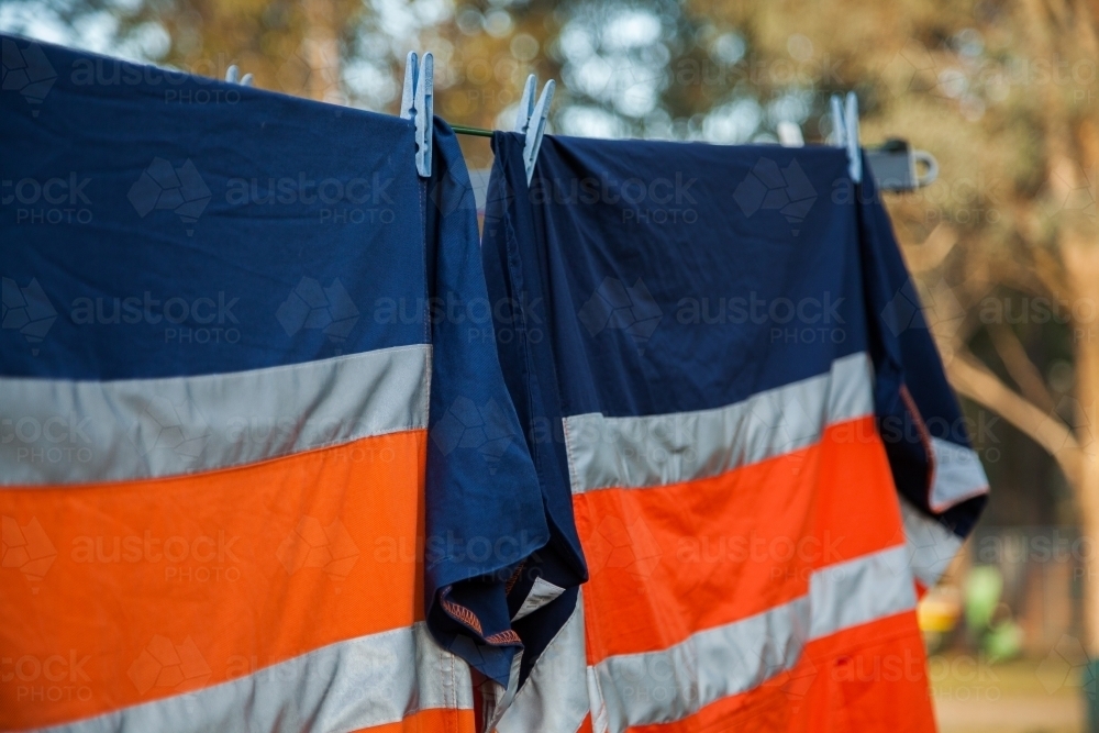 Orange reflective work clothing hanging on the line - Australian Stock Image