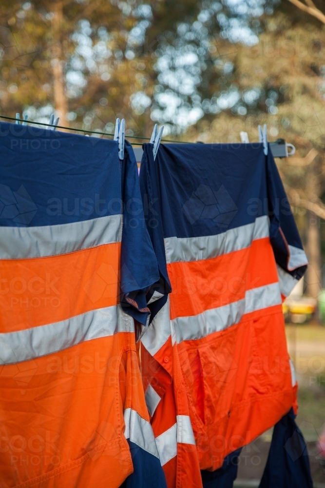 Orange reflective work clothing hanging on the line - Australian Stock Image