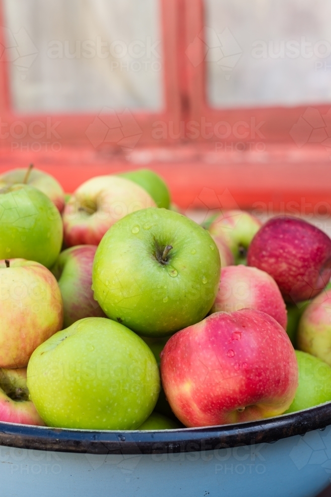 organic apples in a large bowl - Australian Stock Image