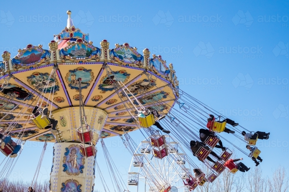 Image of Ornamental swing chair ride with thrill seekers - Austockphoto