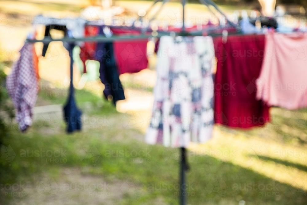 Out of focus hills hoist washing line in the backyard with clothes hanging on it - Australian Stock Image