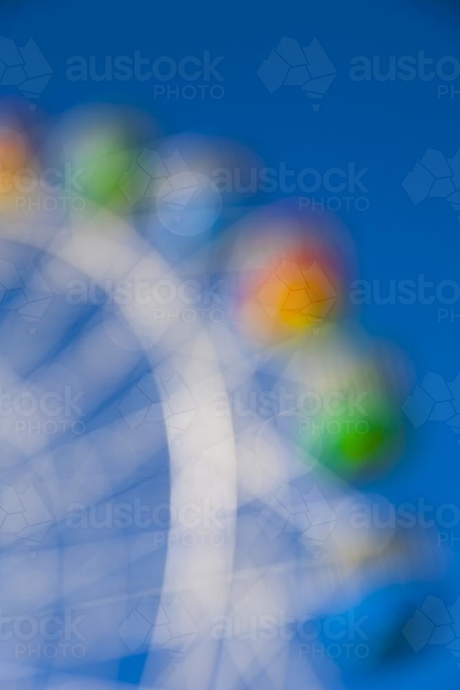Out of focus image of a colourful ferris wheel - Australian Stock Image