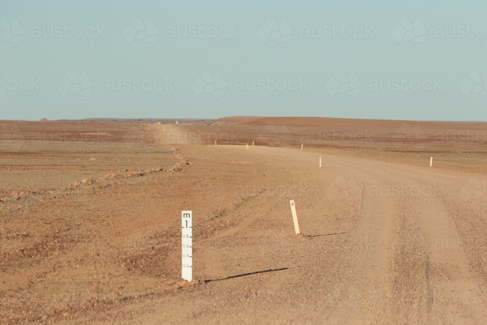 Outback dirt road with flood water gage - Australian Stock Image