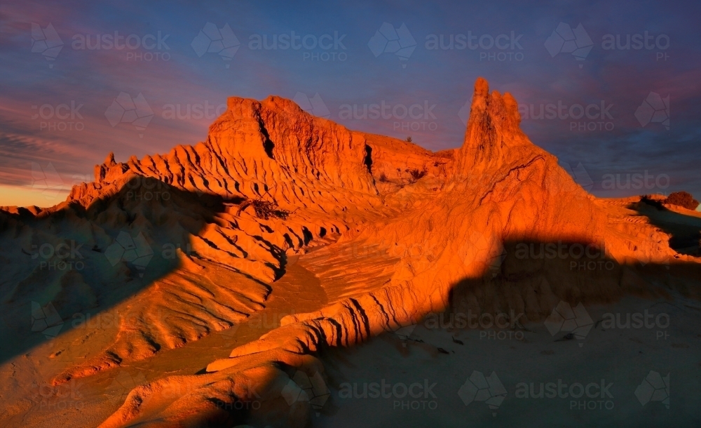 Outback landforms sculpted over time by nature catch the last light of a setting sun - Australian Stock Image