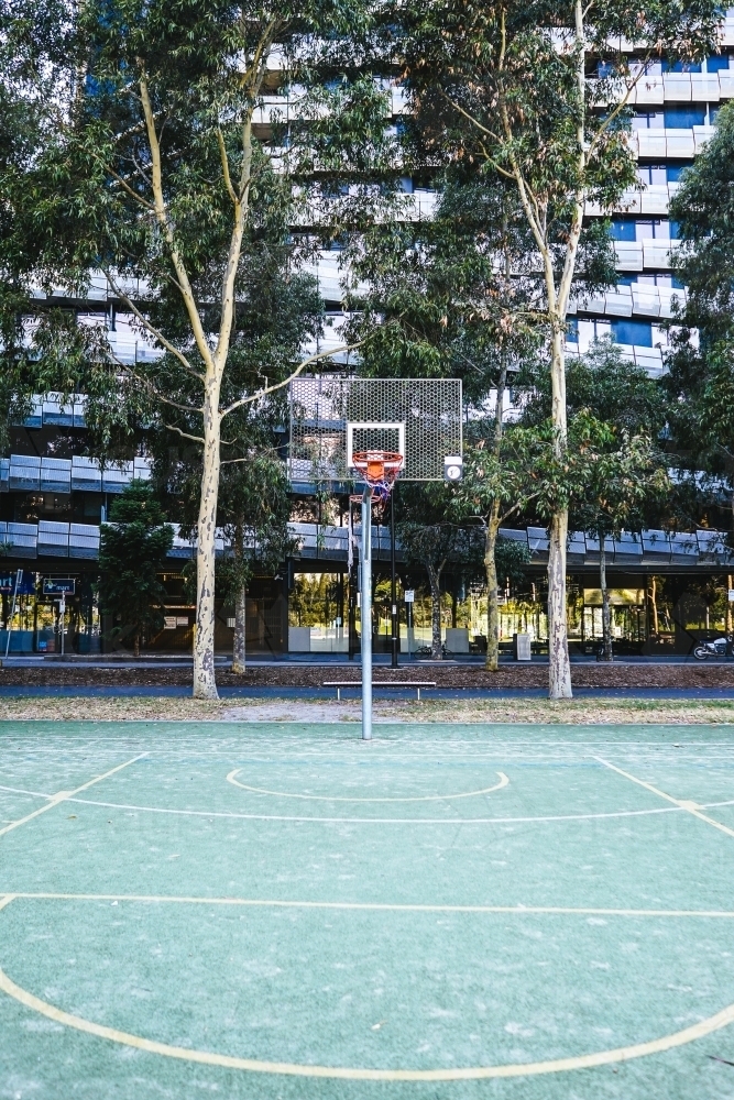 Outdoor basketball court in the city with apartment building in the background - Australian Stock Image