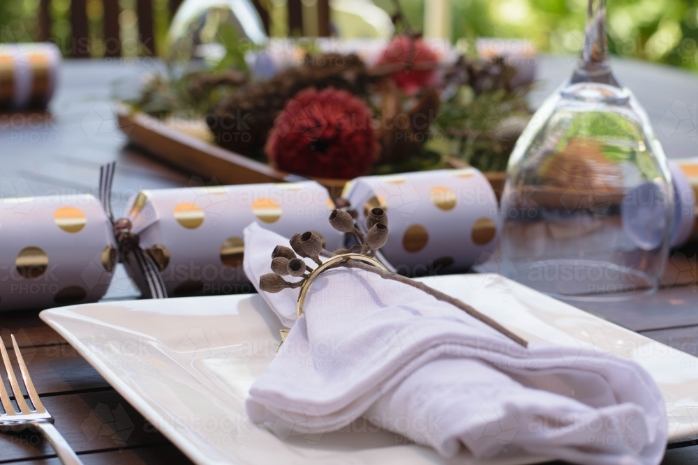 Outdoor Christmas table setting with native flowers and gold and white bon bon - Australian Stock Image