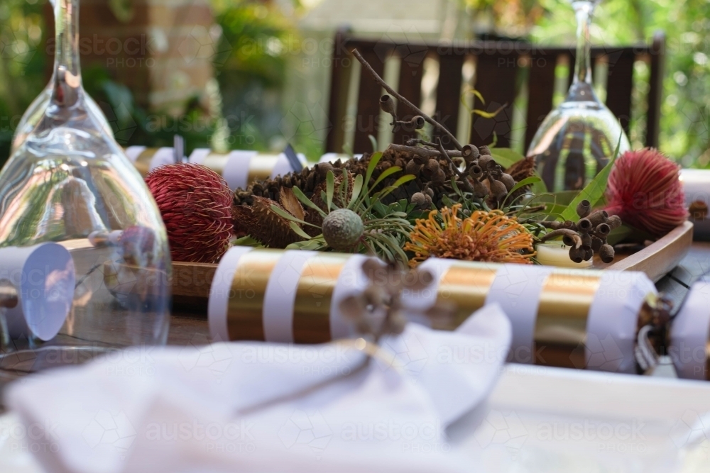Outdoor Christmas table setting with native flowers and gold and white bon bon - Australian Stock Image